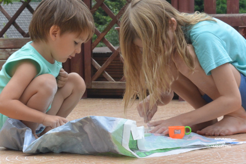 mixed aged boys engaged in fossil digging outdoors - an example of team work that nurtures leadership mindset