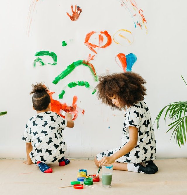 diverse children painting on the wall, creative expression early childhood
