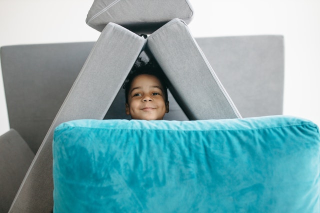 preschool cosy den boy hiding in cushions